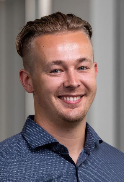 max jenkins, young man with short dark blonde hair and blue eyes dressed in a blue button-down shirt.