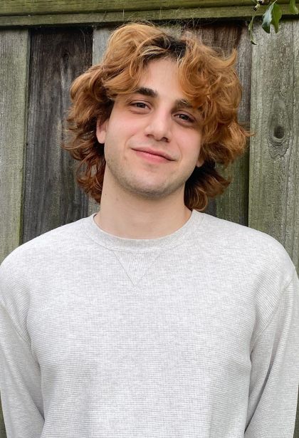 Griffin is a young man with shoulder-length reddish-brown wavy hair